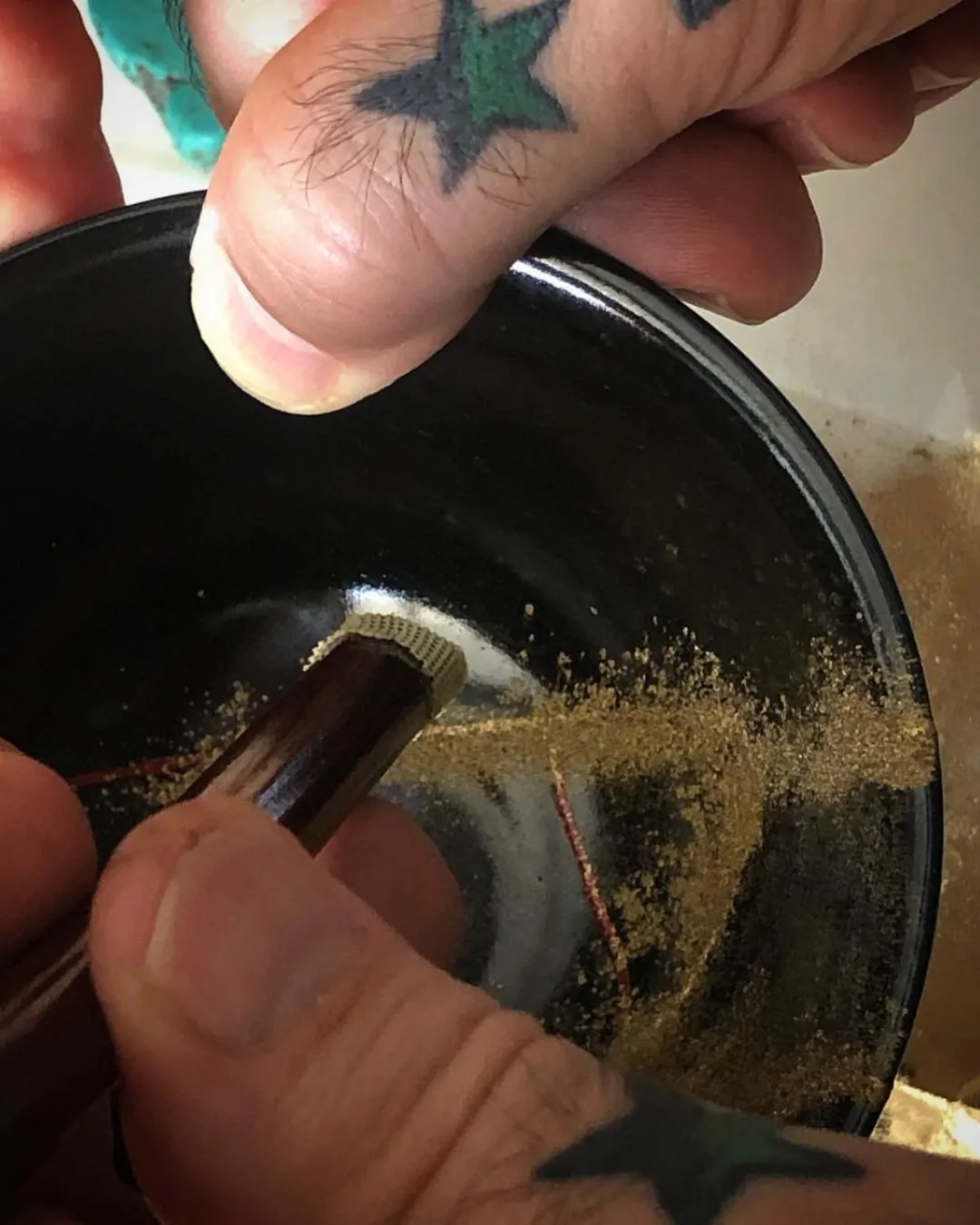Poudre d'or déposée au pinceau sur une ligne de laque