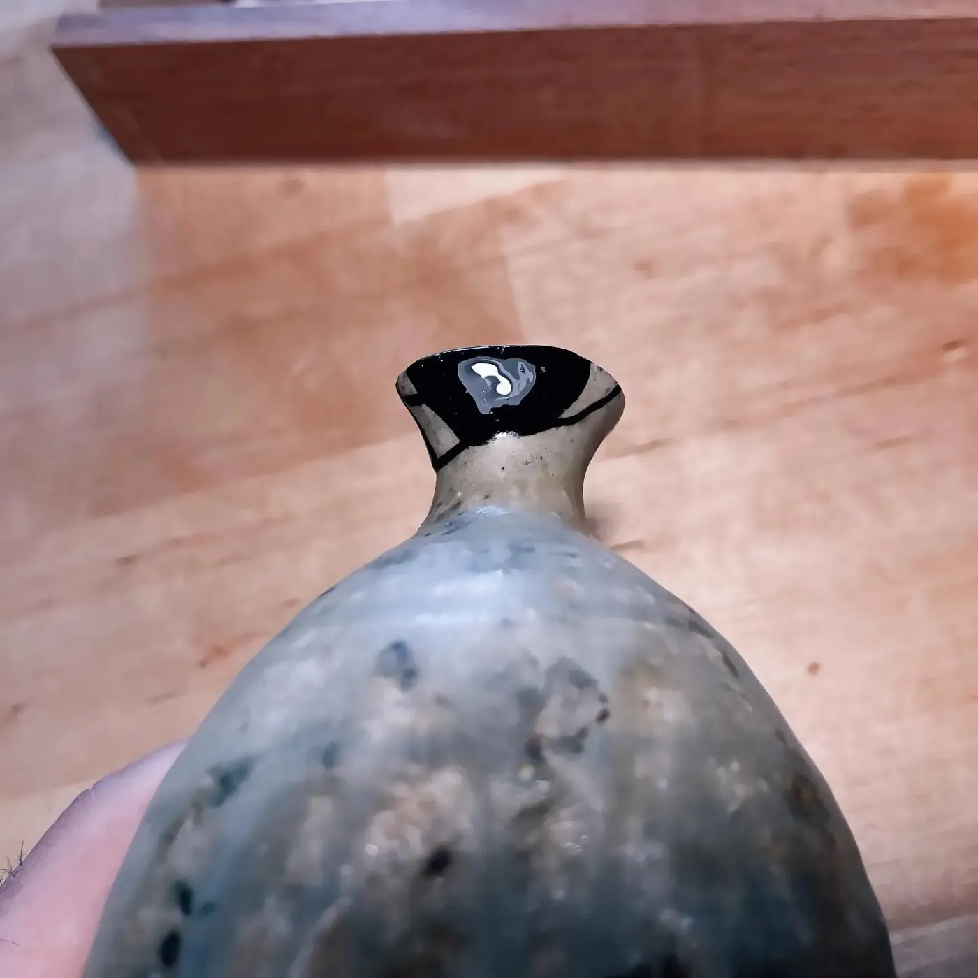 Le col couvert de laque noire brillante sur la partie refaite, pendant les couches poncées une à une.