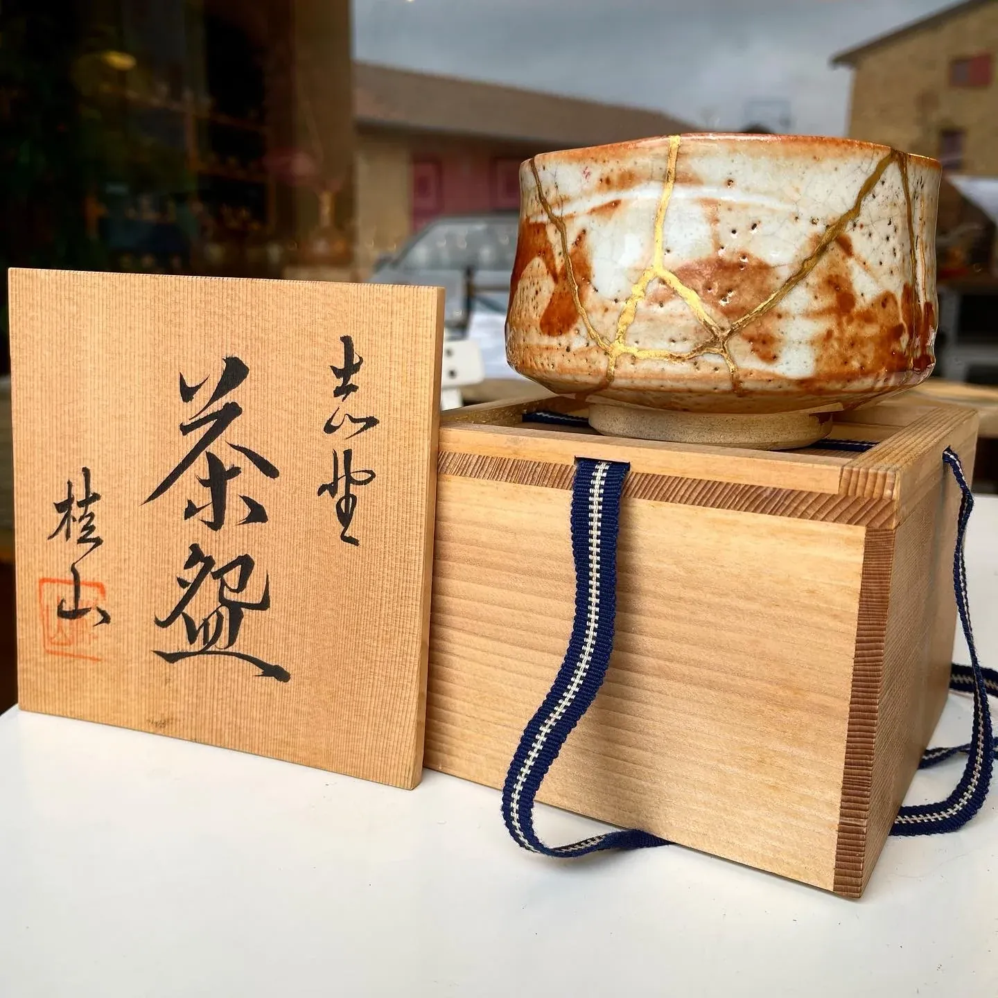 Chawan Shino restauré posé sur sa boîte en bois